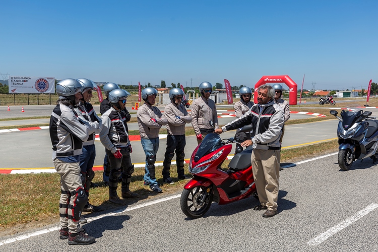 Grupo de motares à volta de uma scooter